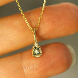 gold teal sapphire pendant on hand 